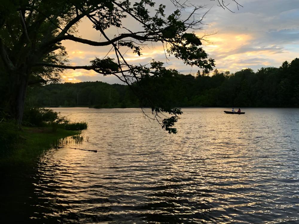 Lake view with boat at site Lakewood Park Campground