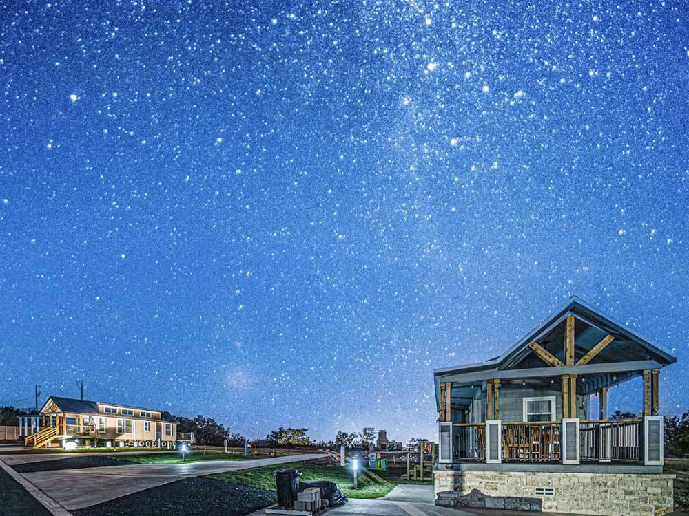 The cabin rentals under a starry night at FIREFLY LUXURY RV RESORT