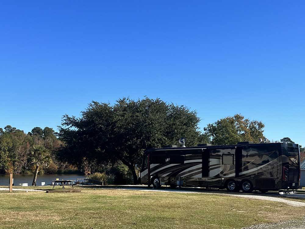 A motorhome parked in a site next to the water at BELLS MARINA RV RESORT