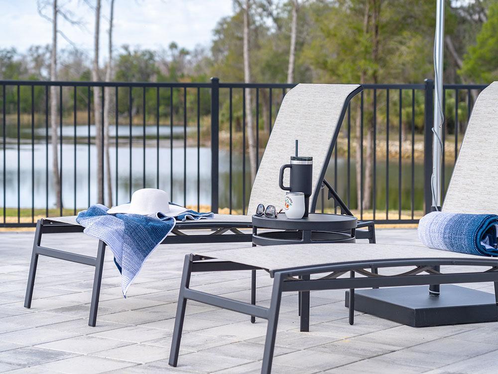 Two pool-side lounge chairs at SWEET CITRUS ACRES RV RESORT