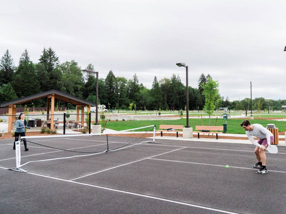 A couple playing pickle ball at  ANGEL OF THE WINDS RV RESORT