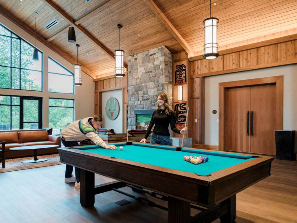 A couple playing billiards in the rec hall at ANGEL OF THE WINDS RV RESORT