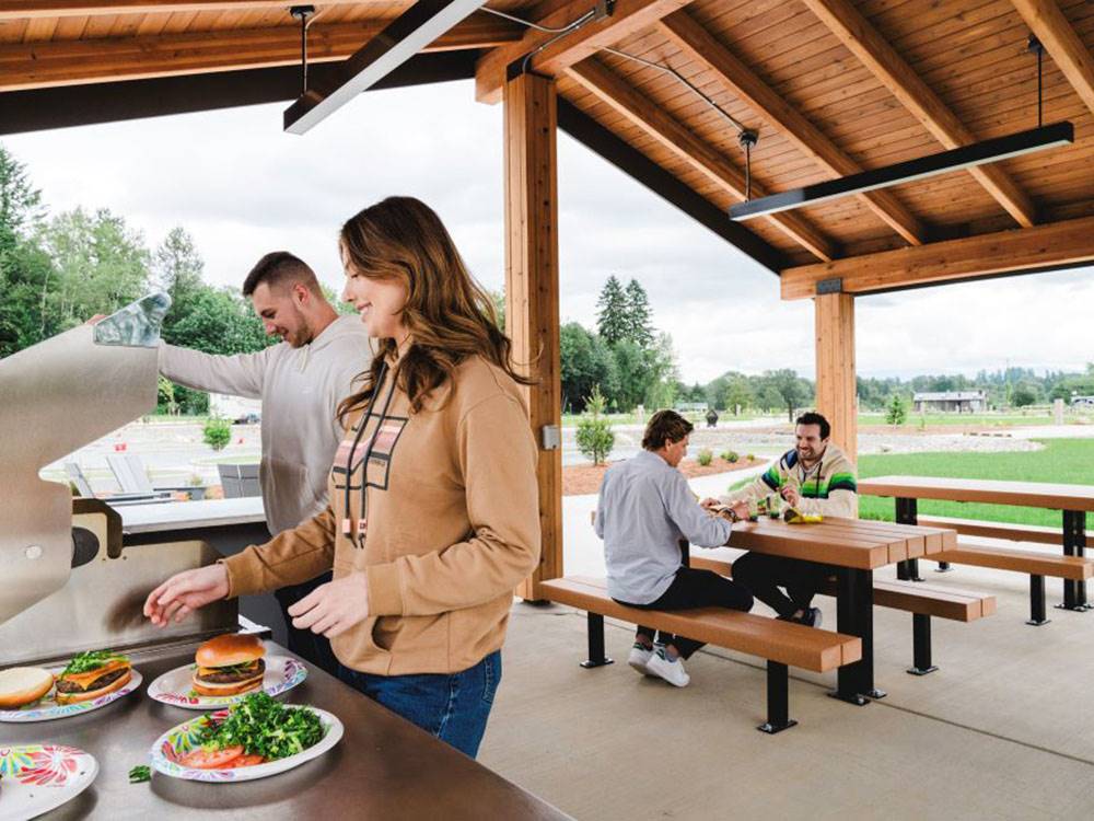 People eating in the outdoor pavilion at ANGEL OF THE WINDS RV RESORT