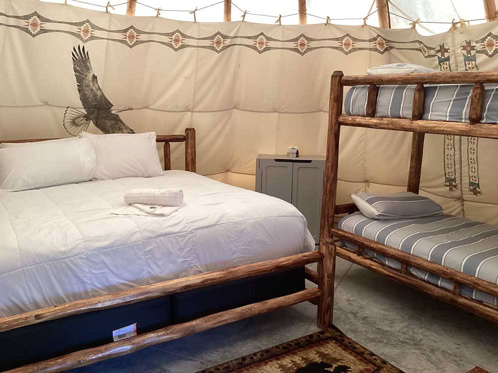 The bed and bunk beds inside the teepee rental at GOD'S COUNTRY RESORT