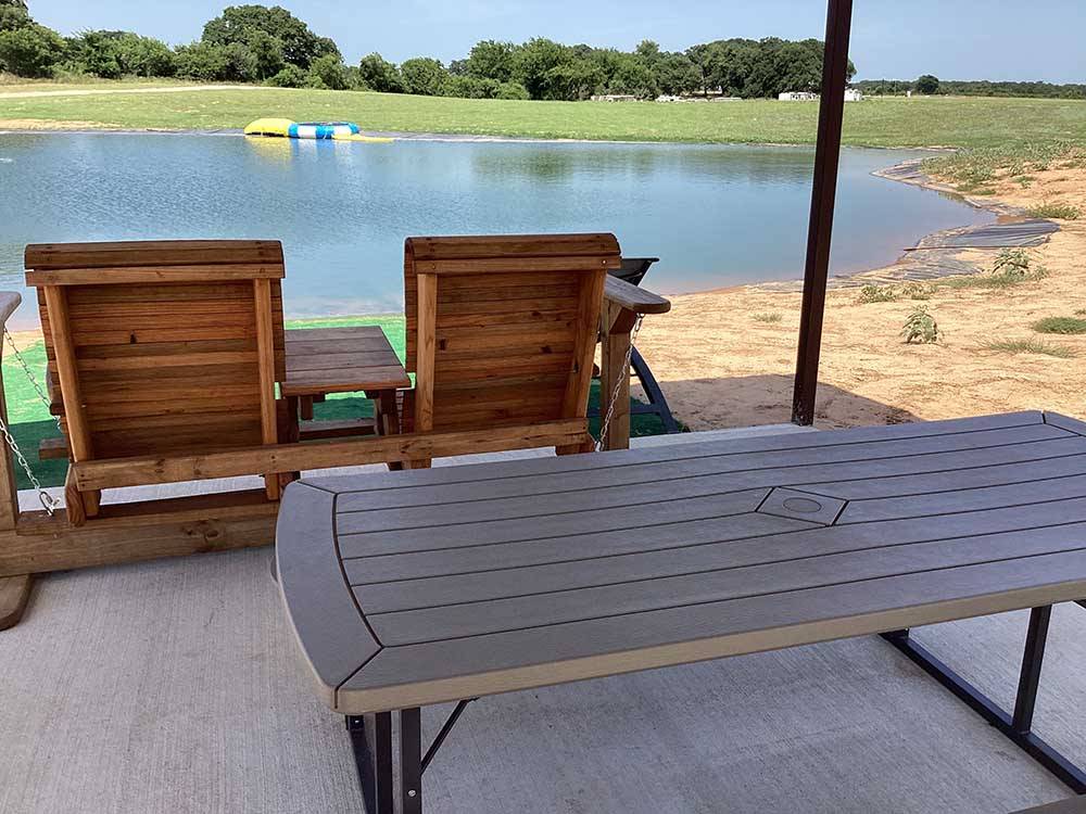 A wooden rocker next to the lake at OLD TOWNE RV RANCH
