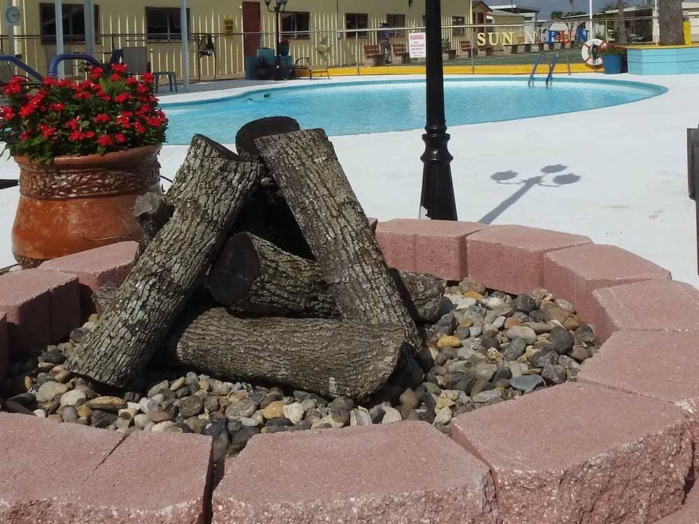 A fire pit near the pool at RIO VALLEY ESTATES 55+ MOBILE/RV PARK