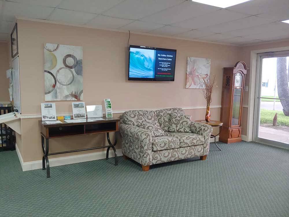 A sofa and TV inside the main office at RIO VALLEY ESTATES 55+ MOBILE/RV PARK