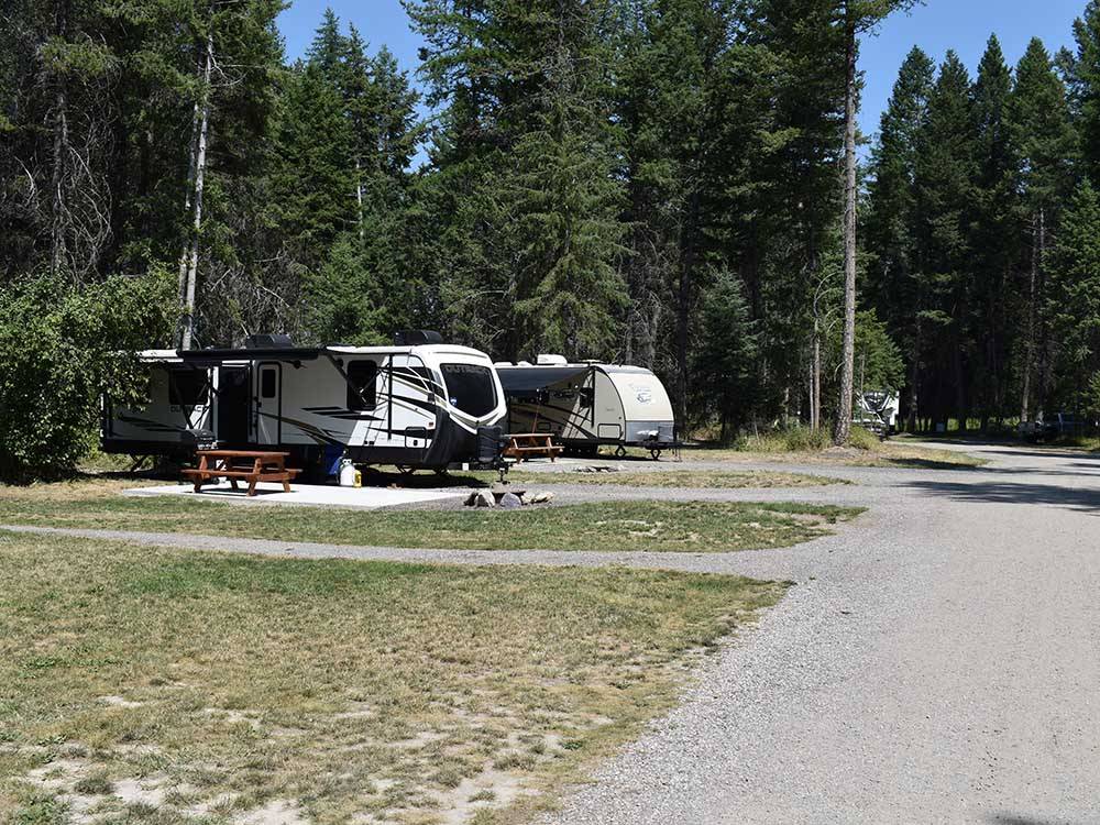 A gravel road leading to RV spots at WHISPERING PINES RV PARK