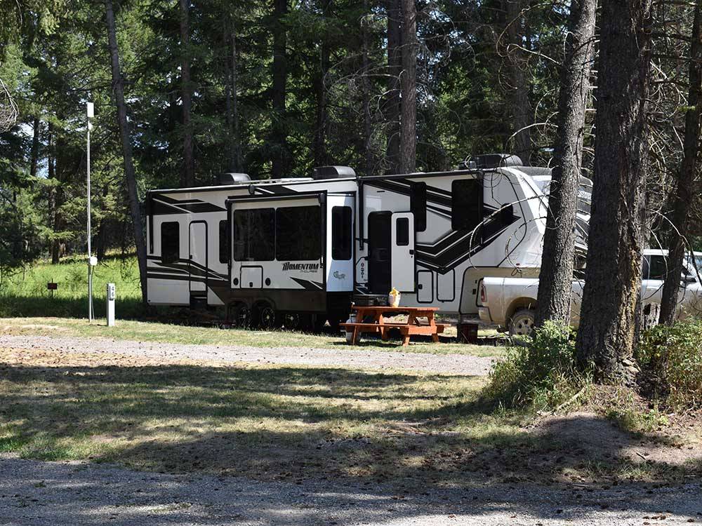 A fifth wheel parked on-site at WHISPERING PINES RV PARK
