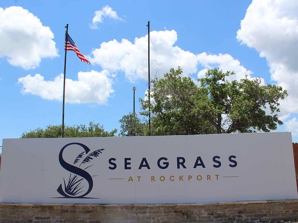 The front entrance sign with a flag at SEA GRASS RV RESORT