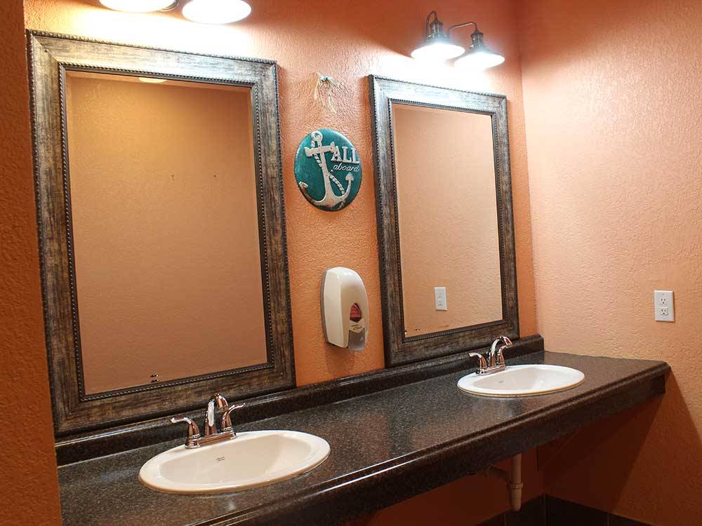 Two bathroom sinks with large mirrors at SEA GRASS RV RESORT