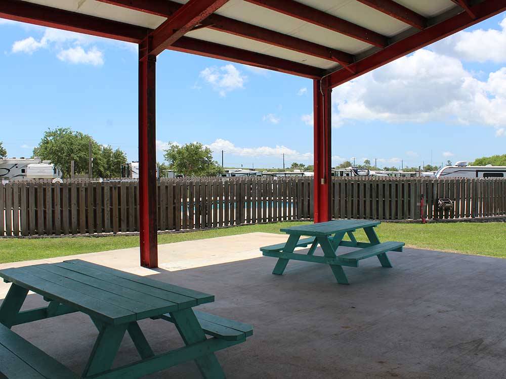 Two blue benches under the pavilion at SEA GRASS RV RESORT