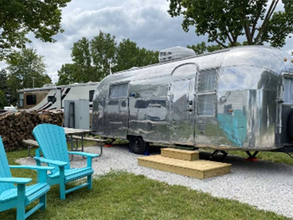 Two blue chairs in front of an Airstream at DANCING FIRE GLAMPING AND RV RESORT