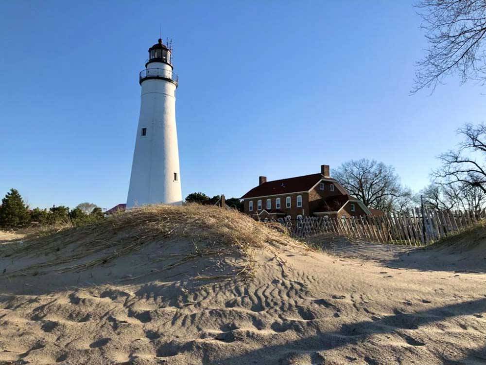 A lighthouse on a mountain of sand nearby at DANCING FIRE GLAMPING AND RV RESORT