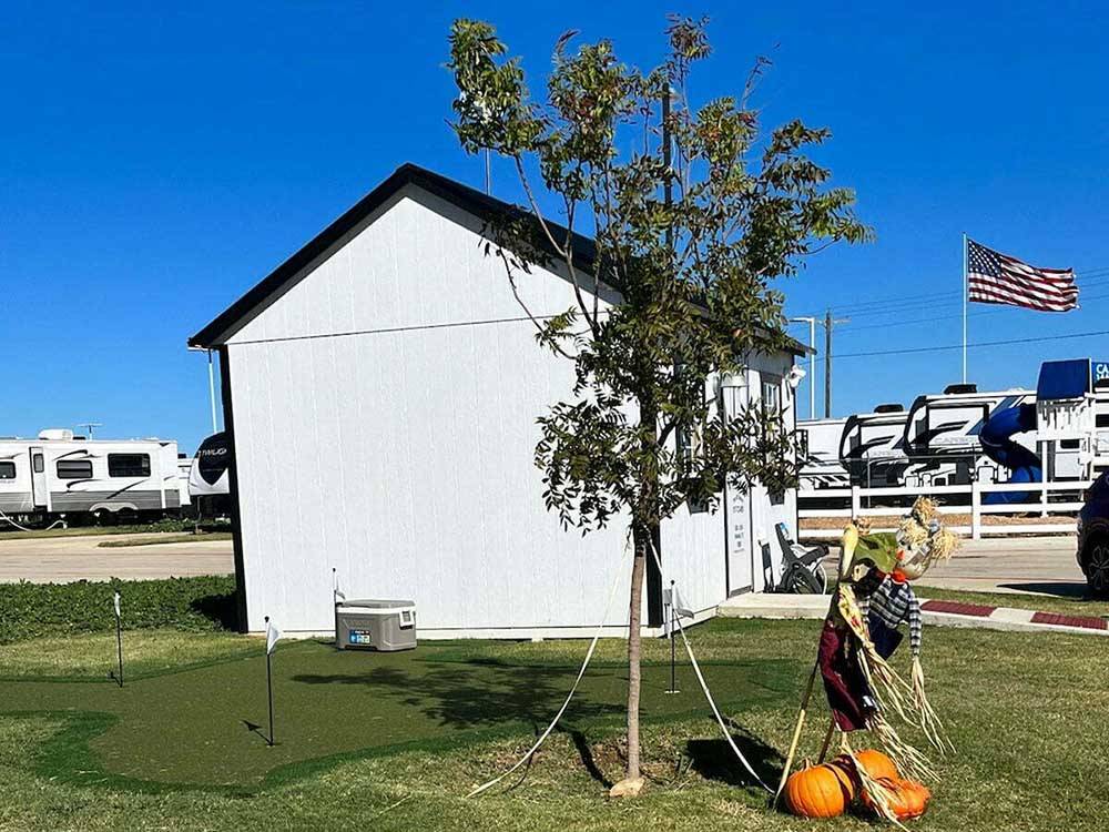 A scarecrow next to a tree and building at THE RV RESORT