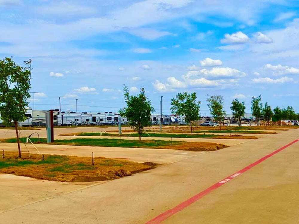 A row of paved RV sites with trees at at THE RV RESORT