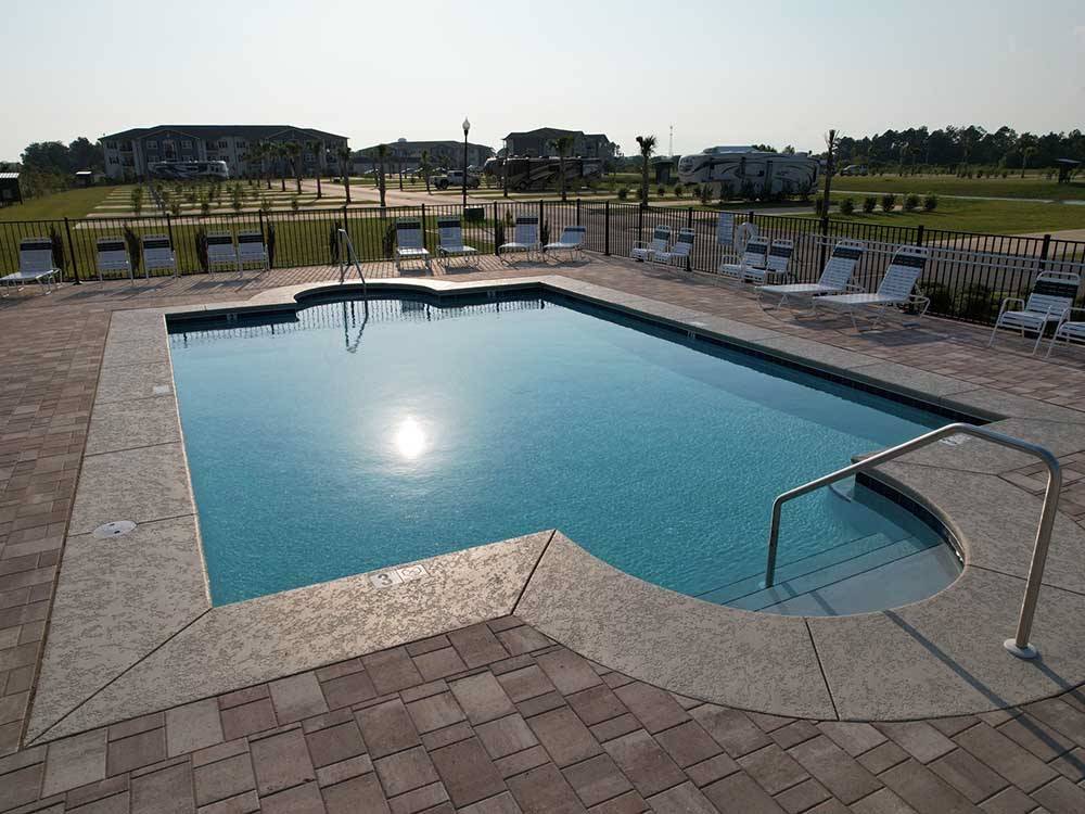 Swimming pool with lounge chairs at GRAND RIVIERA RV RESORT