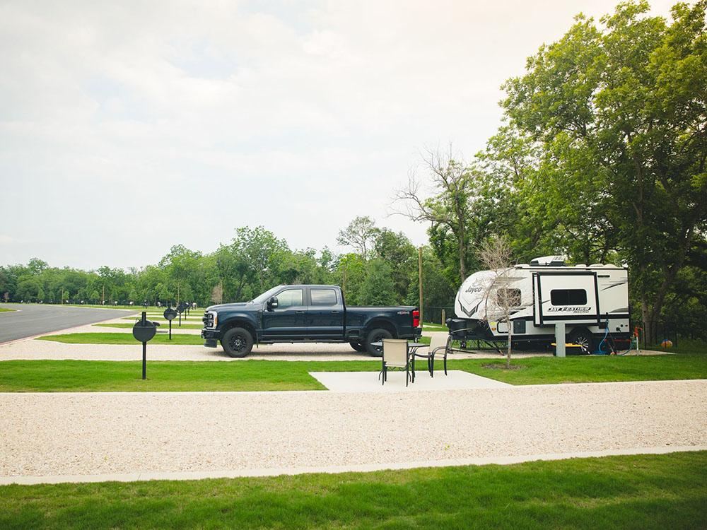 A truck and trailer parked in a site at CAMP LANDA RV RESORT