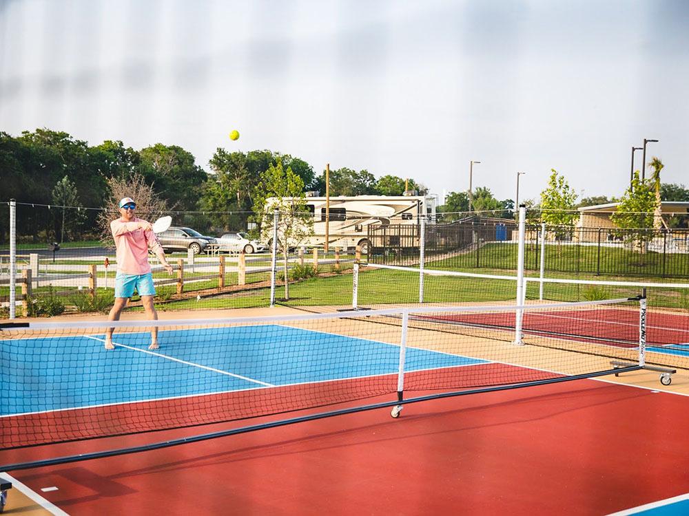 A man playing pickleball at CAMP LANDA RV RESORT