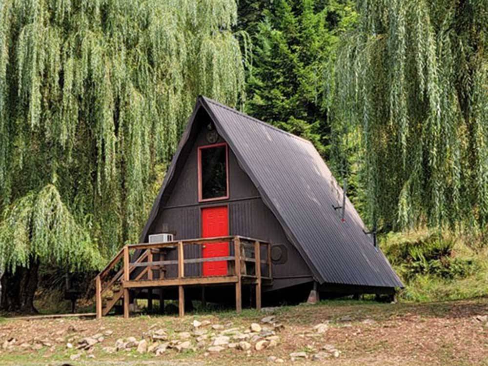 An A-shaped cabin rental with a red door at THREE RIVERS RESORT
