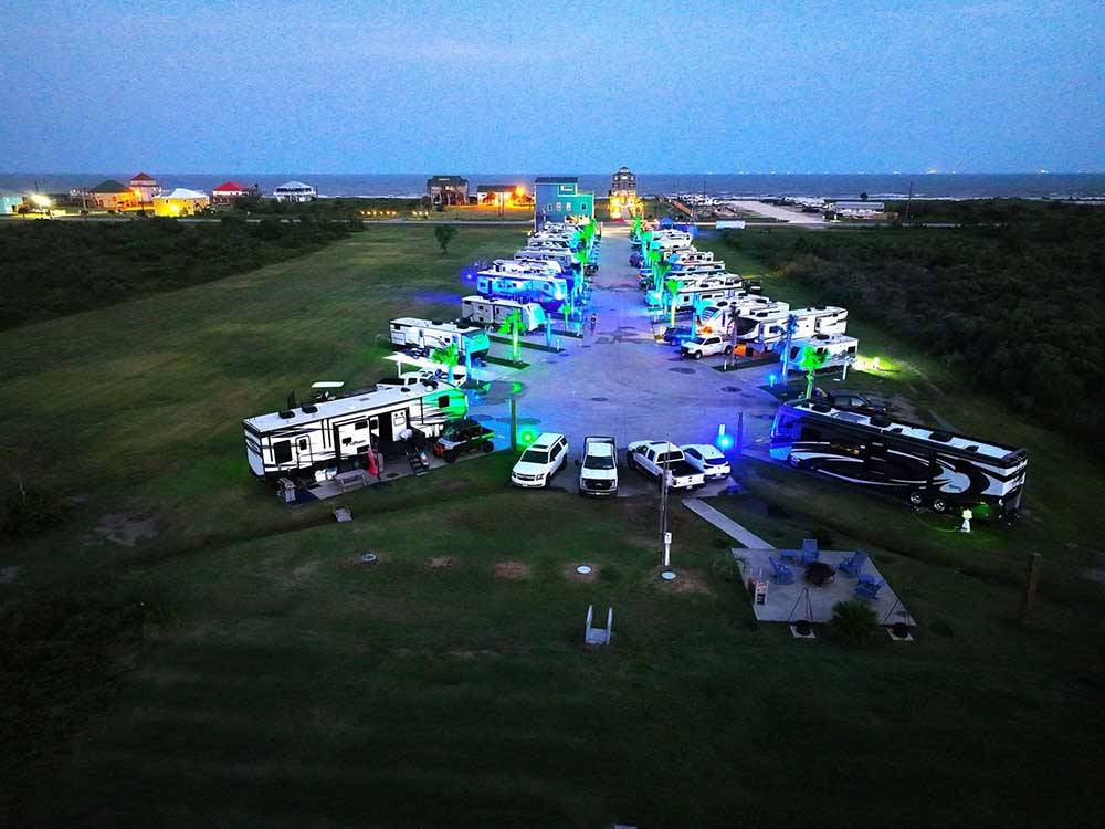 Aerial view of the filled up RV sites lit up at night at THE PALAPA RV BEACH RESORT