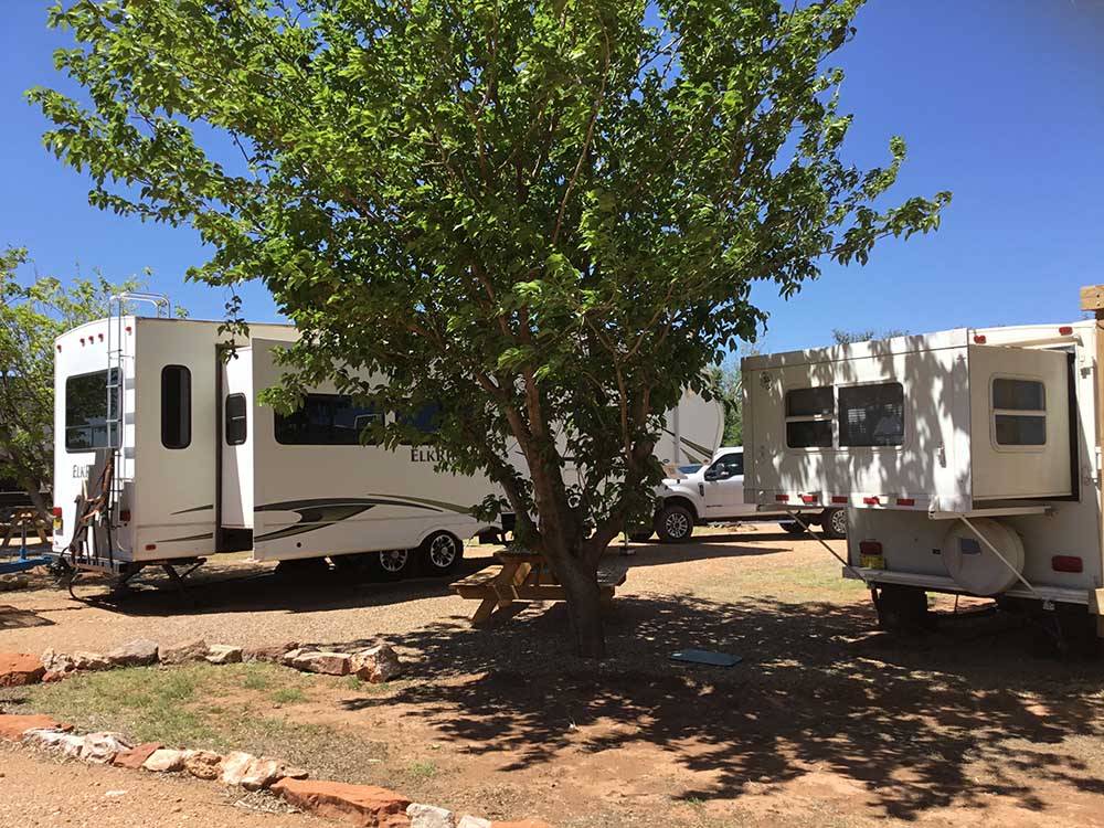 Two trailers parked in dirt sites at SHEPHERD FAMILY CABINS & RV CAMPGROUND