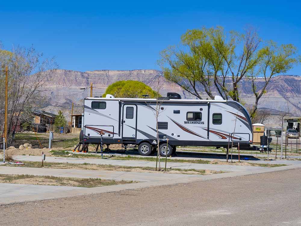 A travel trailer parked in a paved site at ESQUIRE ESTATES MH & RV PARK