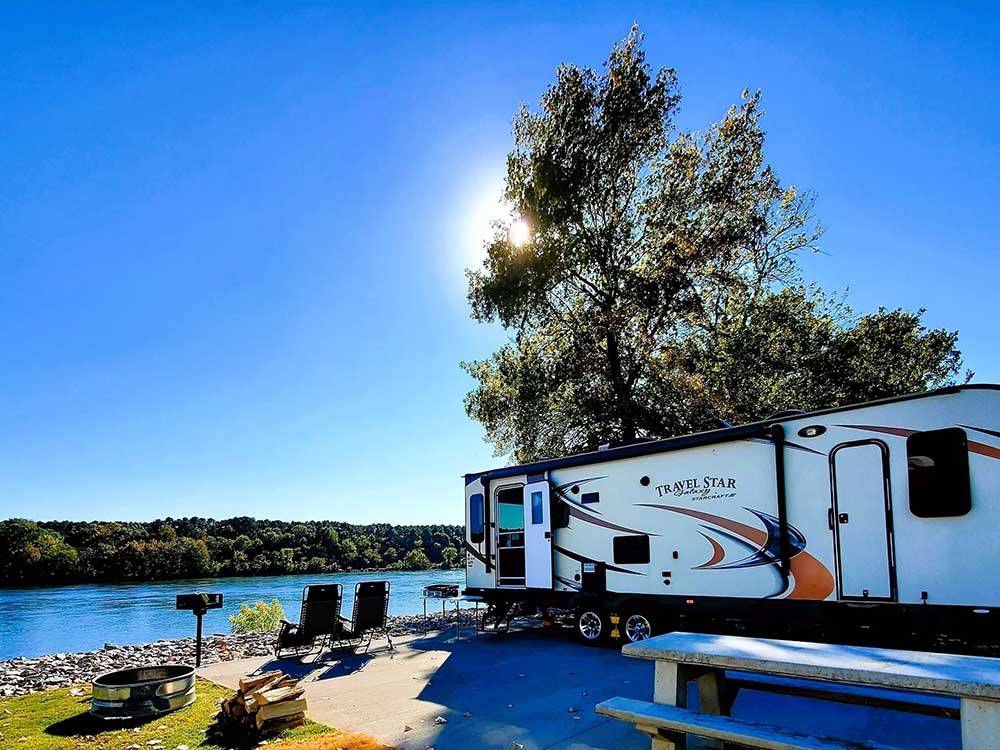 A trailer backed in with a river view at BOTEL CAMPGROUND