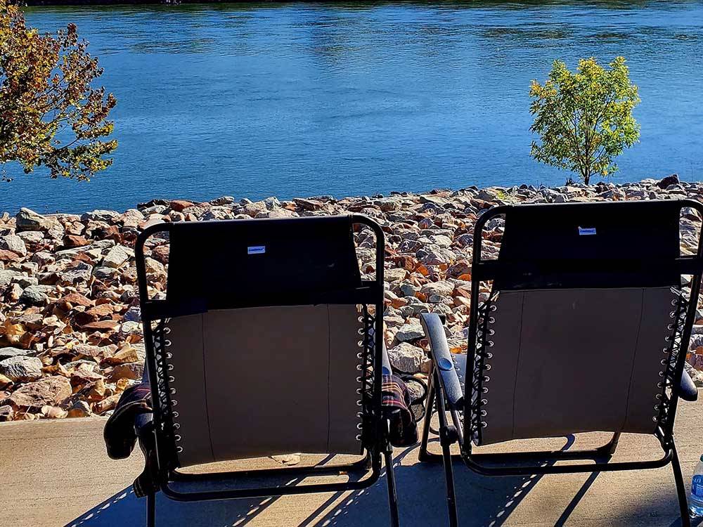 Two lounge chairs looking out to the river at BOTEL CAMPGROUND