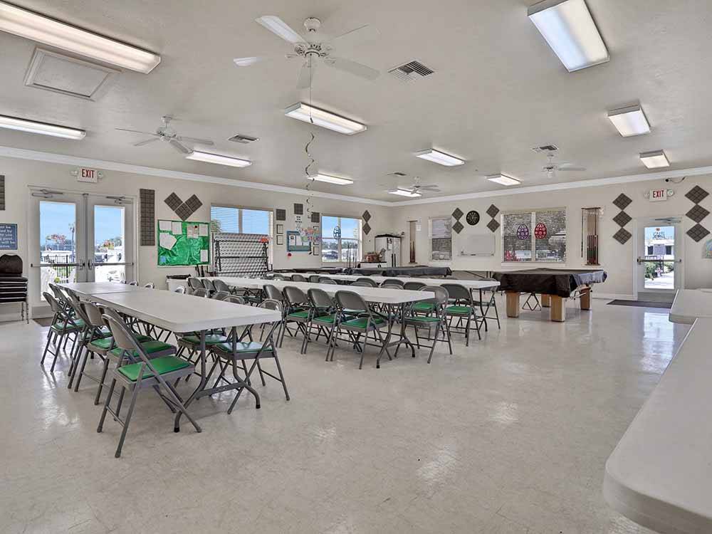 Long tables and chairs in the rec room at COACH HOUSE MOBILE HOME PARK