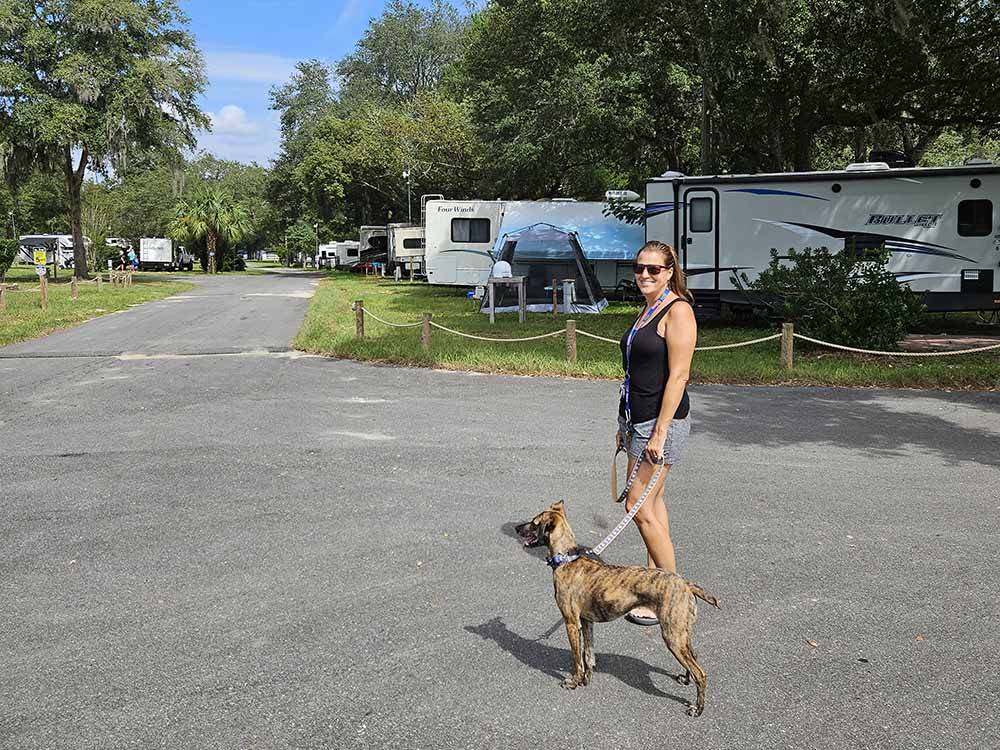 A lady walking with her dog at COOPER LAKE RV COMMUNITY