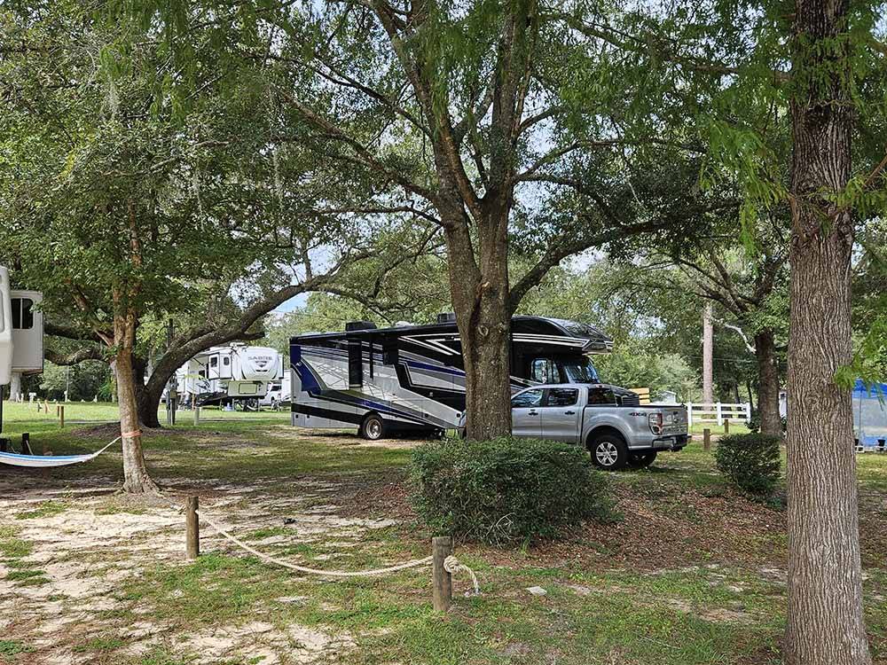 A Class C trailer parked under trees at COOPER LAKE RV COMMUNITY