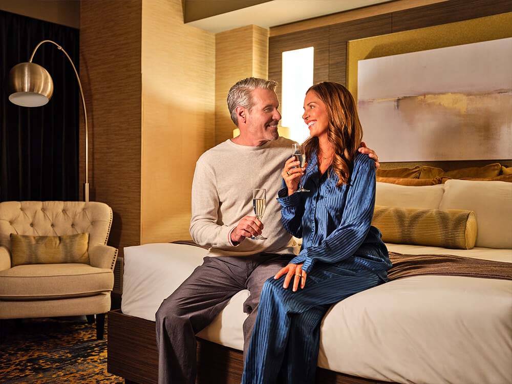 A couple drinking wine in one of the hotel rooms at SPIRIT MOUNTAIN CASINO RV PARK
