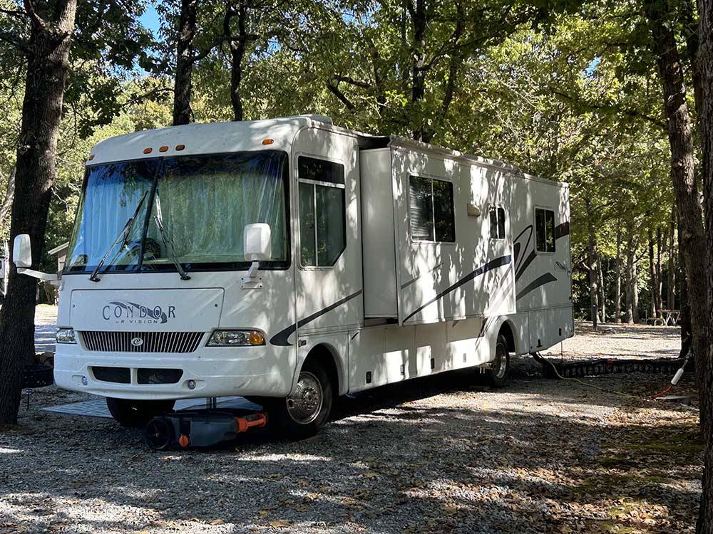 A Motorhome parked under the tall trees at RUSTIC RIDGE