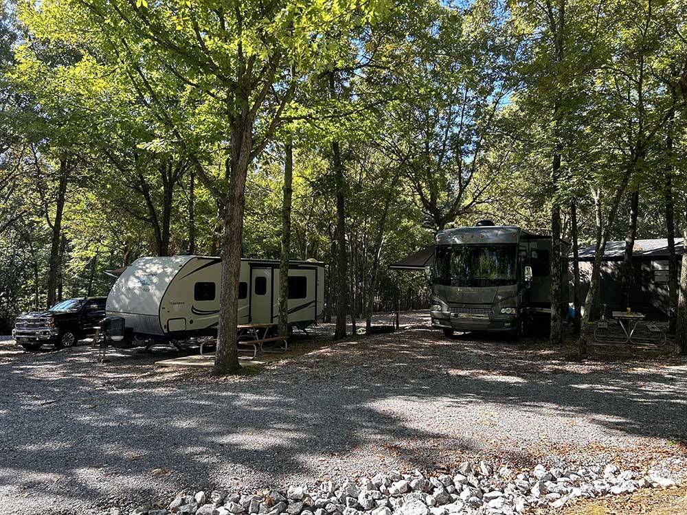 A trailer and Motorhome parked in RV sites at RUSTIC RIDGE