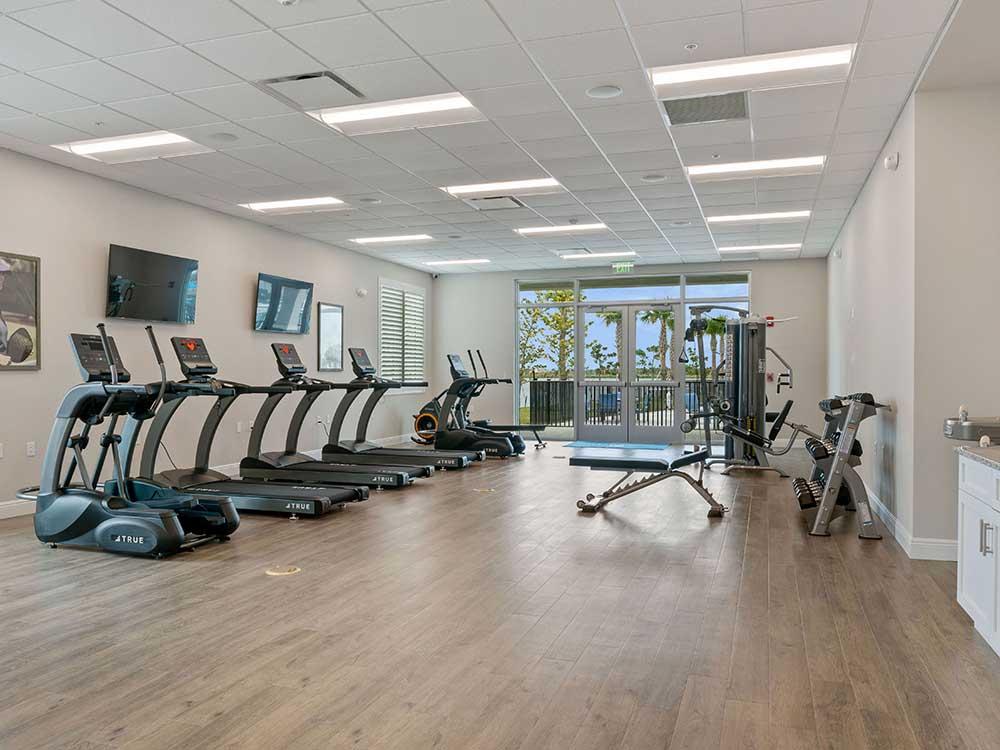 A row of treadmills in the exercise room at ENCORE TRANQUILITY LAKES