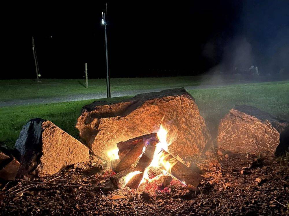 A nighttime campfire near large rocks
