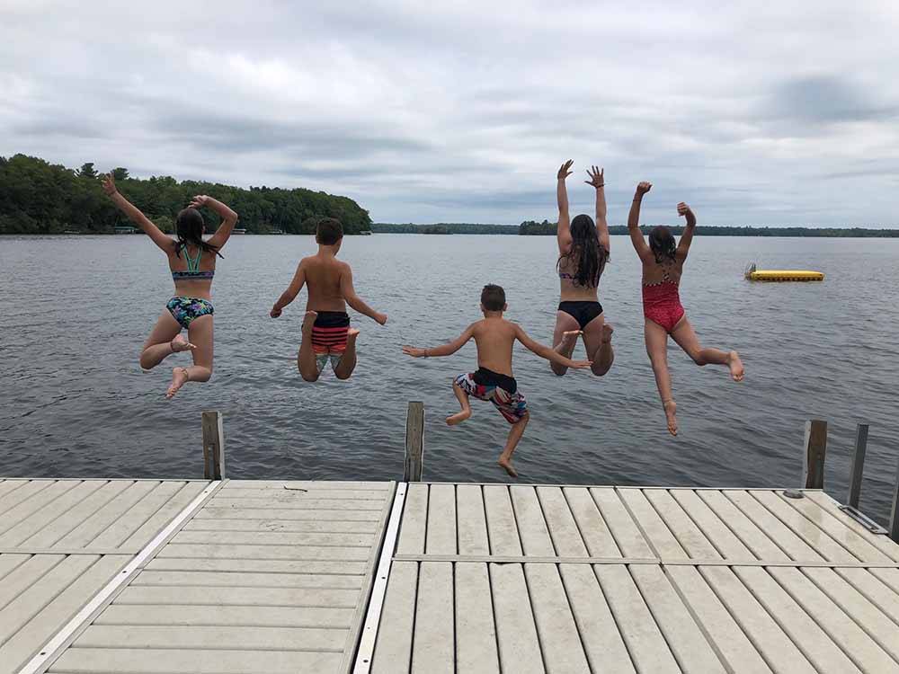 Kids jumping into the lake at GATHERING PLACE RESORT & LODGE