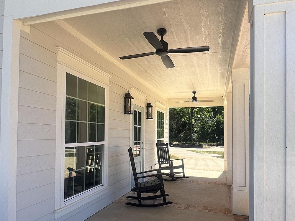 Porch with rocking chairs and overhead fan at STARRVILLE RV RESORT