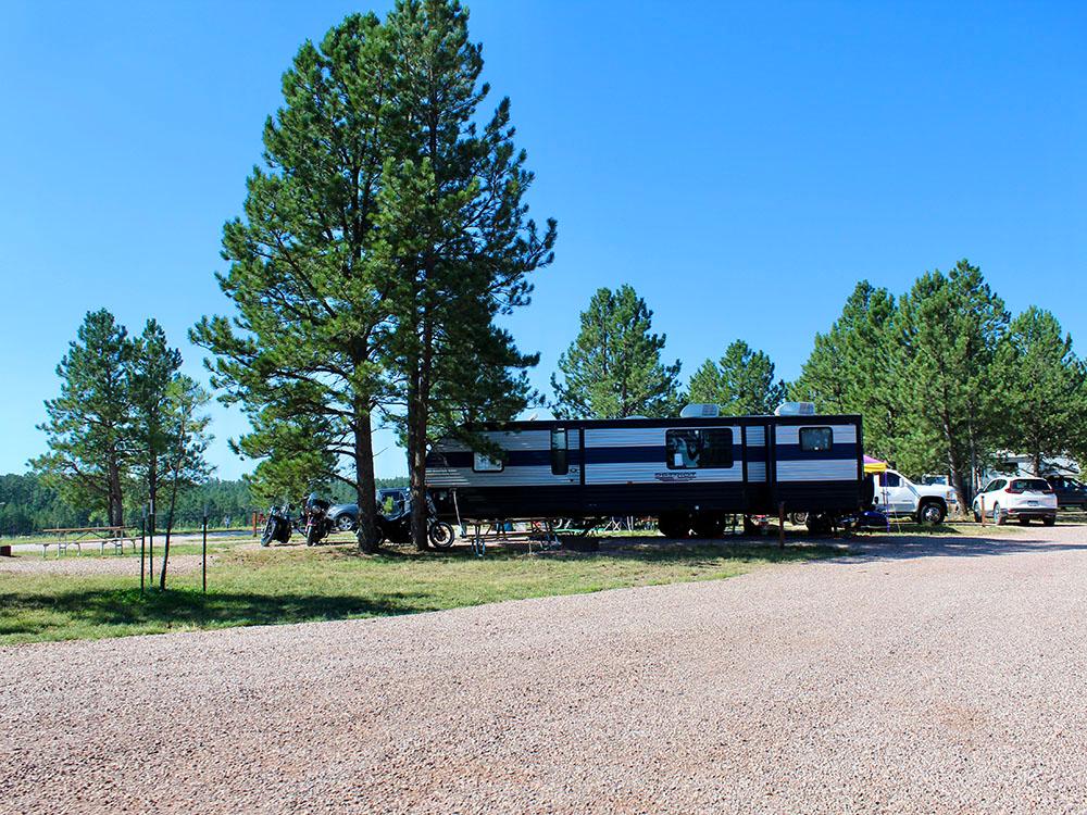 Large fifth-wheel trailer and motorcycles parked at site at PINE HAVEN VENUE & LODGING