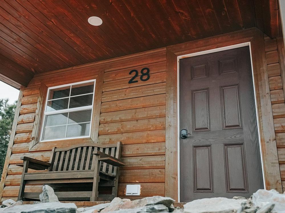 A bench on the porch of a rental cabin at PINE HAVEN VENUE & LODGING