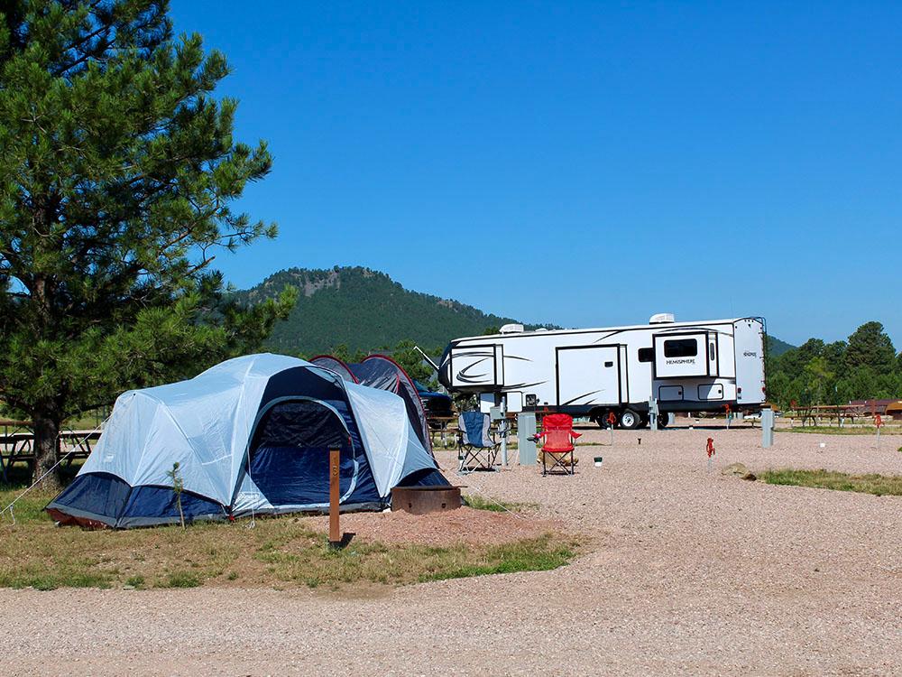 A pitched tent and RV at site at PINE HAVEN VENUE & LODGING