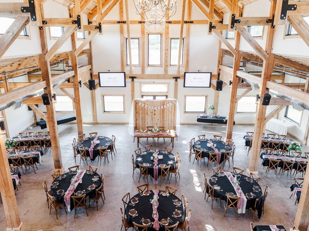 View of the rec hall with tables set for an event at PINE HAVEN VENUE & LODGING