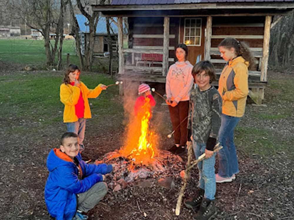 A family around a campfire at HEAVENLY HILLS NATURE RETREAT