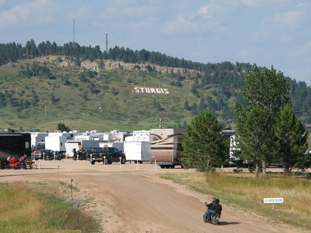 A couple on a motorcycle entering the park