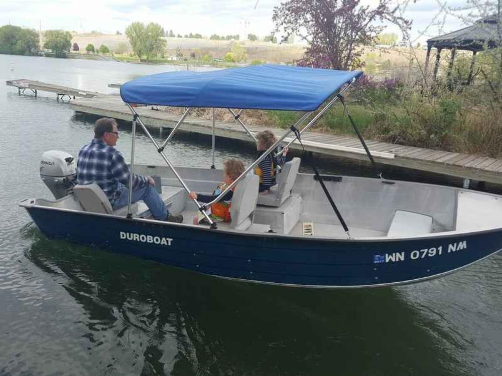 family in a small blue boat at Cascade Marina & Resort