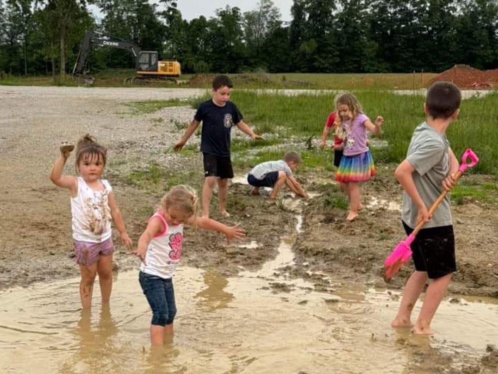 Kids playing in muddy water at THE LANDING STRIP CAMPGROUND