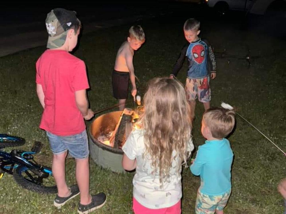 Kids roasting marshmallows at THE LANDING STRIP CAMPGROUND