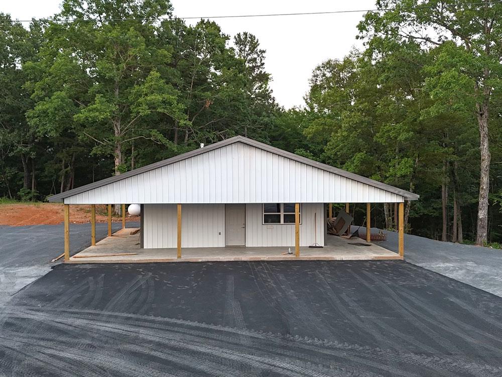 The office building and paved parking area at DEW DROP IN