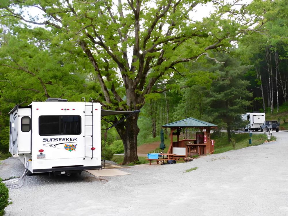 An RV with slide-outs in a shady site